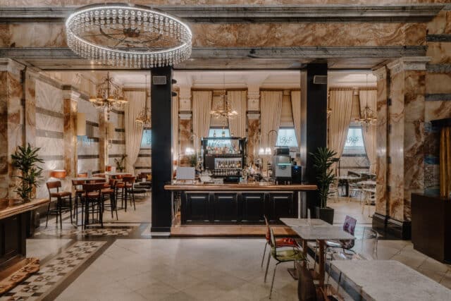 white chandelier in front of black and brown bar and beige patterned floor