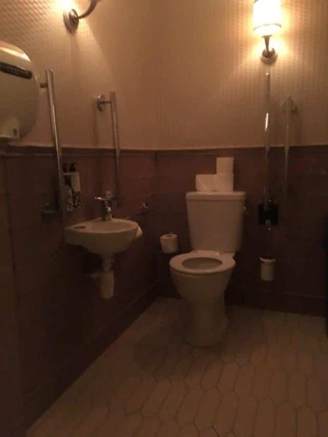 Kettner's Disabled Toilet is Actually Brighter Than This Photo Suggests & Has All 5 Grab Bars. Can't Remember If There's a Mirror But The Decor Fits With the Rest of The Building.
