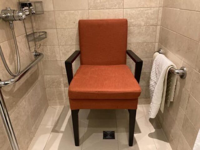 NArrow Shower Room With Orange Armchair